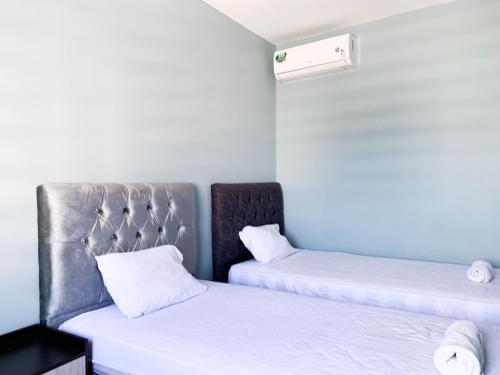 two beds in a room with white sheets at Hermosa casa en Salinas! in Salinas