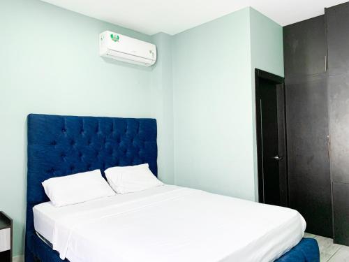 a bedroom with a large bed with a blue headboard at Hermosa casa en Salinas! in Salinas