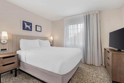 a bedroom with a large white bed and a television at Sonesta ES Suites Torrance Redondo Beach in Torrance