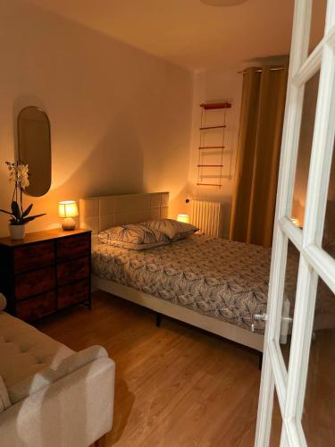 une chambre avec un lit, une commode et un miroir dans l'établissement Grand appartement, 300m des transports en commun, à Fontenay-sous-Bois