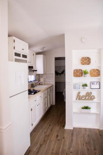 a kitchen with white cabinets and a white refrigerator at Clyde's Cabin with a private Hot Tub in Carthage