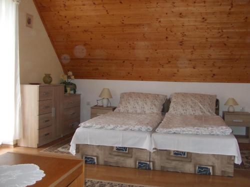 ザラカロシュにあるDorina Apartmanの木製の天井が特徴のベッドルーム1室(ベッド2台付)