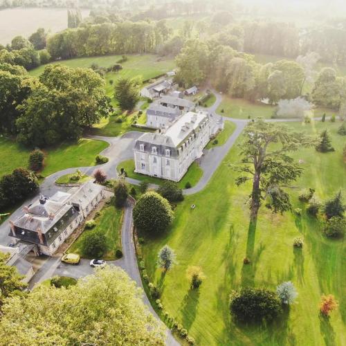 - une vue aérienne sur une grande maison avec une cour dans l'établissement Gîte le bûcher du château, à Barbeville