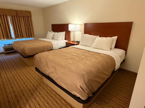 a hotel room with two beds and a window at Quality Inn & Suites in Eau Claire