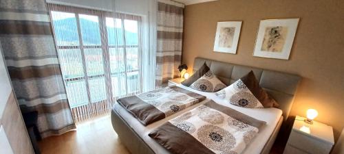 a bedroom with two beds and a large window at Ferienwohnung Harlachbergblick 1-Activ Card in Bodenmais