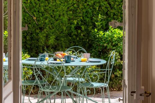 une table d'extérieur avec des chaises et des oranges dessus dans l'établissement Garden-Level Apartment in Bourgeois Residence Near Croisette & Beaches, à Cannes