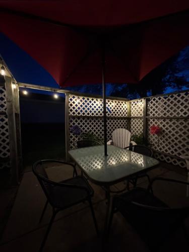 a table and chairs on a balcony with an umbrella at Contemporary Cutie in Lincoln