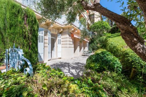 une maison avec un arbre devant dans l'établissement Garden-Level Apartment in Bourgeois Residence Near Croisette & Beaches, à Cannes