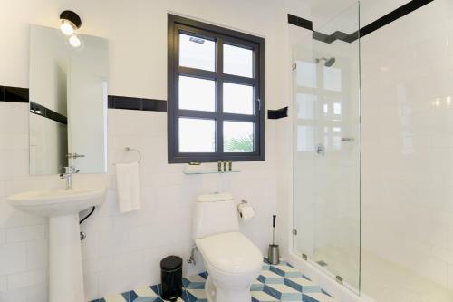 a bathroom with a toilet and a sink and a shower at La Manzana By Wynwood House in Paloma