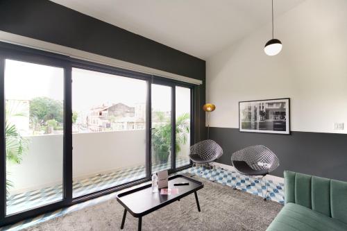 a living room with a couch and a large window at La Manzana By Wynwood House in Paloma