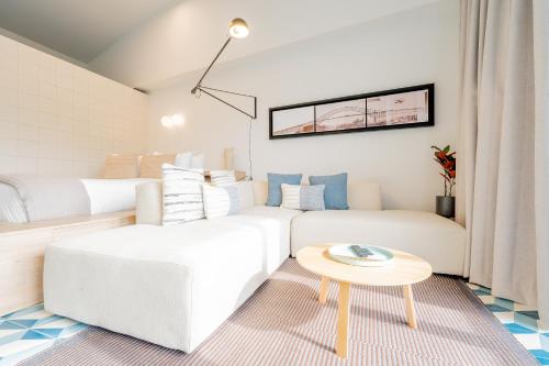 a living room with a white couch and a table at La Manzana By Wynwood House in Paloma