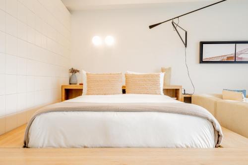a white bedroom with a bed and a couch at La Manzana By Wynwood House in Paloma
