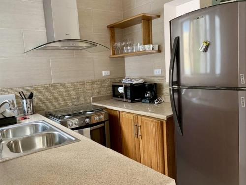 a kitchen with a stainless steel refrigerator and a sink at Casa La Maria Zona Colonial in Santo Domingo