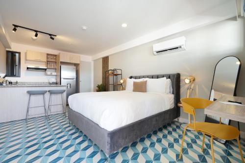 a bedroom with a large bed and a kitchen at La Manzana By Wynwood House in Paloma