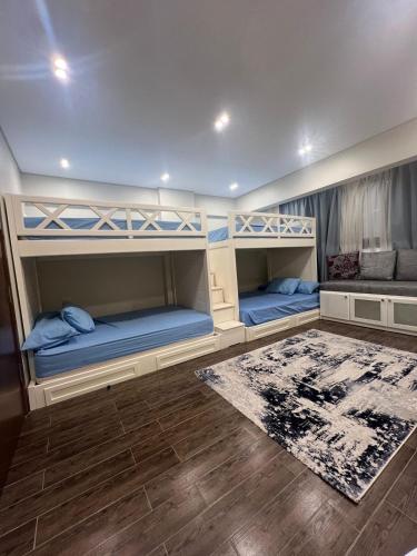 two bunk beds in a room with a rug at Charming Apartment - Near Cairo Airport in Cairo