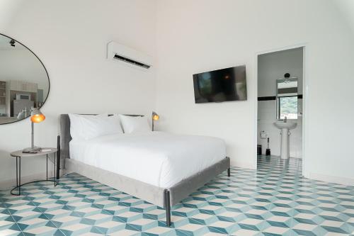 a bedroom with a white bed and a blue and white floor at La Manzana By Wynwood House in Paloma