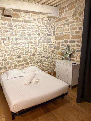 un lit dans une chambre avec un mur en pierre dans l'établissement Étoile du Vieux Lyon, à Lyon