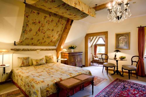 a bedroom with a king sized bed and a chandelier at Hotel Burg Arras in Alf