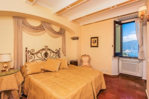 a bedroom with a bed and a large window at Villa Alba d'Oro - Historic luxury villa in Amalfi
