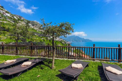 two chaise lounges in the grass next to the ocean at Villa Alba d'Oro - Historic luxury villa in Amalfi