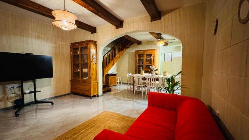 a living room with a red couch and a table at See You Mystic Flowers & Pool in Għarb