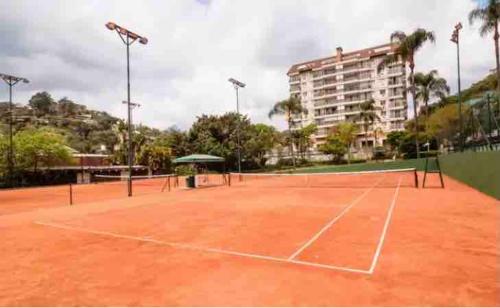 ein Tennisplatz vor einem Gebäude in der Unterkunft Flat em Itaipava! in Araras Petropolis