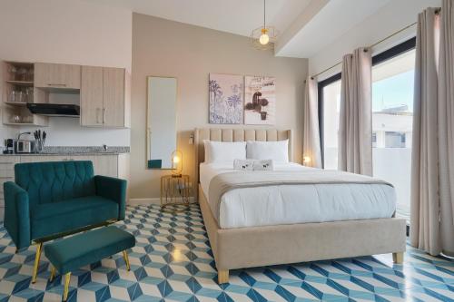 a bedroom with a bed and a green chair at La Manzana By Wynwood House in Paloma