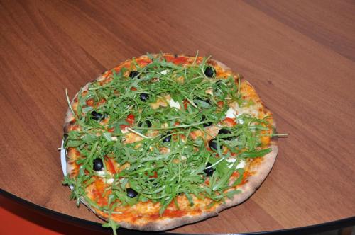 a pizza sitting on top of a wooden table at Albergo Stazione in Bodio
