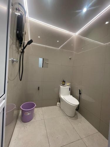 a bathroom with a toilet and a phone on the wall at Tanah Embah RumahLima melayu sahaja in Banting
