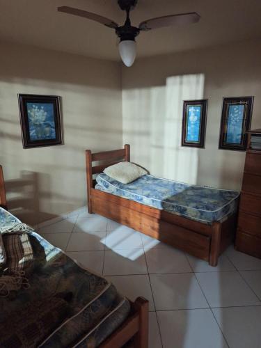 a bedroom with two beds and a ceiling fan at Casa Serra Macaé in Água Boa