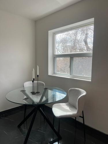 a dining room with a glass table and two chairs at Cozy Bohemian Apartment in Toronto