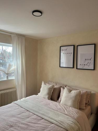 a bedroom with a bed with white sheets and a window at Cozy Bohemian Apartment in Toronto