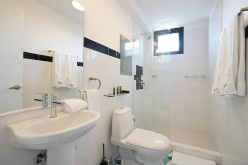 a white bathroom with a sink and a toilet at La Manzana By Wynwood House in Paloma