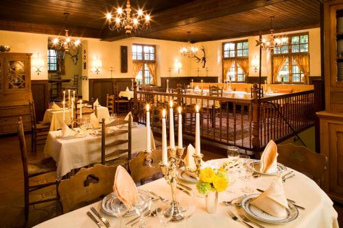 un comedor con mesas blancas y velas. en Hotel Burg Arras, en Alf