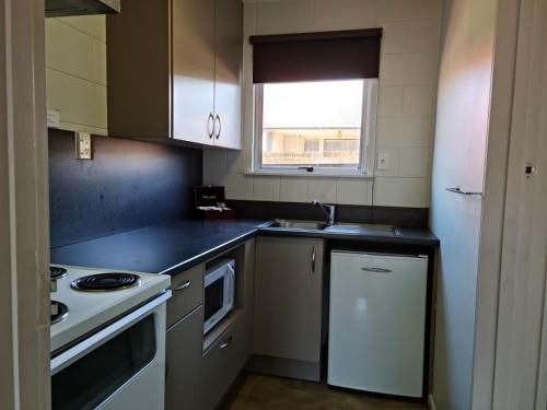 a kitchen with a white stove and a sink at Cranford Cottages and Motel in Christchurch