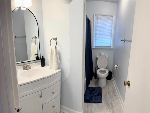a bathroom with a sink and a toilet with a mirror at New! Special Rate for First Bookings! 2 Bedroom in Charlotte