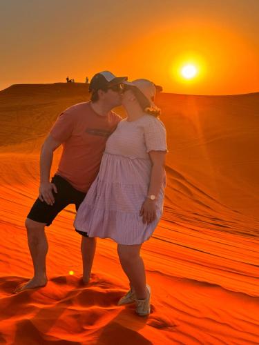 a man and a woman kissing in the desert at Sunset Luxury camps in Dubai