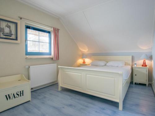 a bedroom with a white bed and a window at Aquamarijn in Stavoren