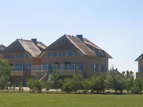 a large house with a grass field in front of it at Aquamarijn in Stavoren