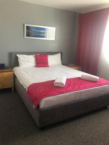 a bedroom with a bed with a red and white blanket at Vila Orizont Straja in Straja