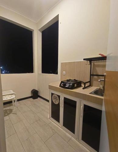 a kitchen with a counter and two large windows at de Pipo Bromo in Sukapura