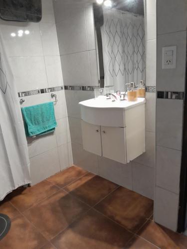 a white bathroom with a sink and a mirror at Departamento Anita Villa Carlos Paz in Villa Carlos Paz