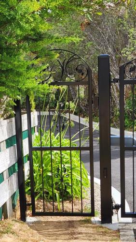 an iron gate with a garden behind it at Boutique Art Retreat in Upper Hutt