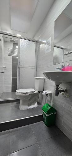 a bathroom with a toilet and a sink and a shower at Hotel El Buen Descanso in Filandia