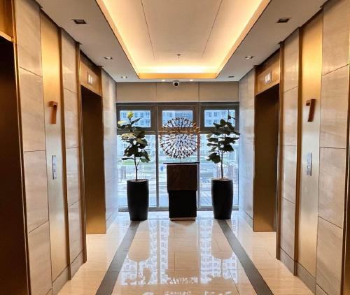 a hallway with three potted plants in a building at Ortigas Business District Residences in Manila
