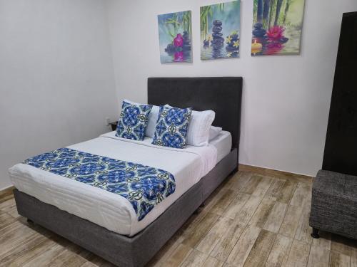 a bedroom with a bed with blue and white pillows at Hotel El Buen Descanso in Filandia