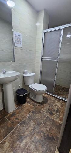 a bathroom with a toilet and a sink and a shower at Hotel El Buen Descanso in Filandia