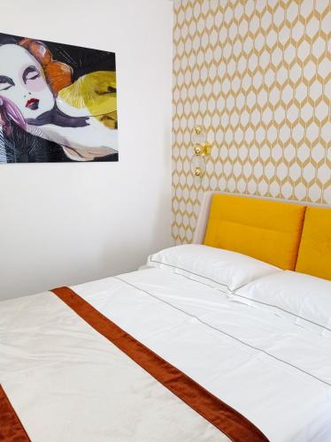 a bed in a room with a painting on the wall at La Giulietta in Tortorella