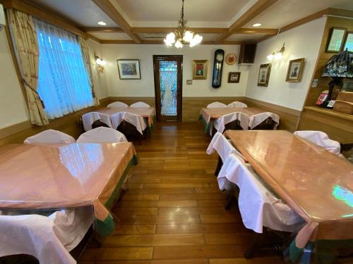 a dining room with tables and white chairs at ビジネスイン拝島 in Akishima