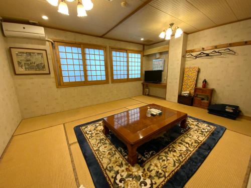 a living room with a wooden table and a rug at ビジネスイン拝島 in Akishima